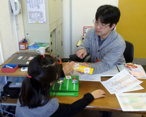 診察場面で自閉症児とＰＥＣＳを使ってコミュニケーションをとる田中さん